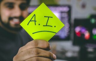Man holding a Post-it with “A.I.” written